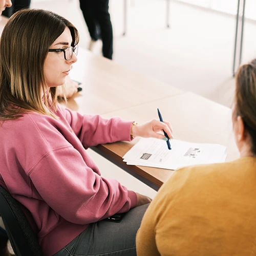 Adult woman in classroom taking notes