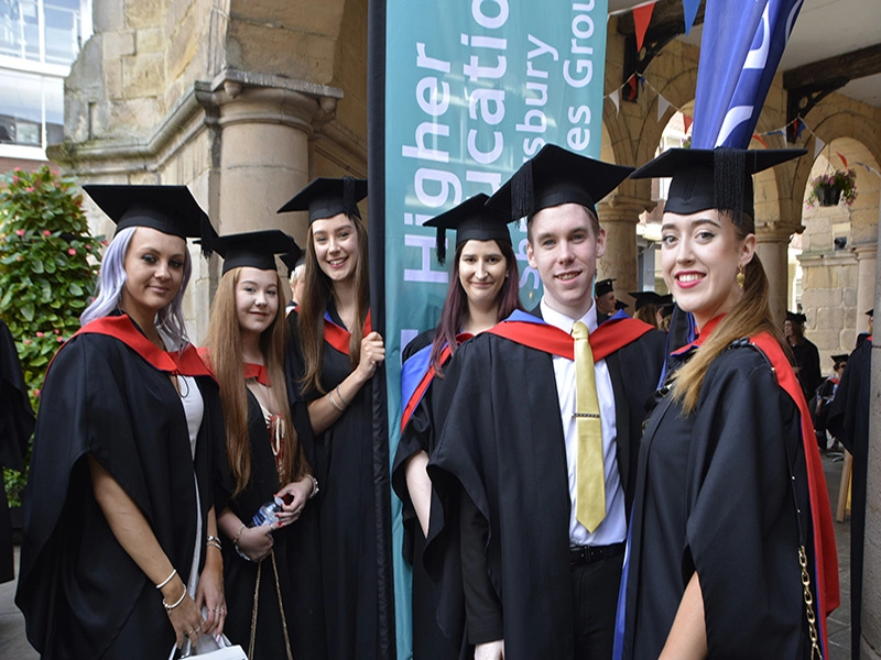 Graduation students standing together in cap and gown