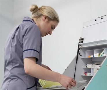 Nurse looking at medicine trolley 