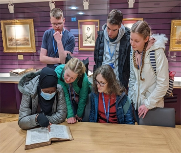 Group of students looking at first edition of Newton's Principia