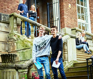 Six A Level students standing and sitting on the steps at English Bridge Campus