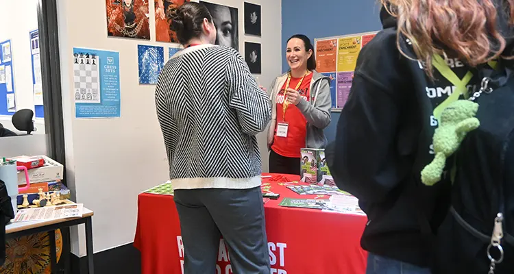 Student talking to person on Race Against Blood Cancer stand