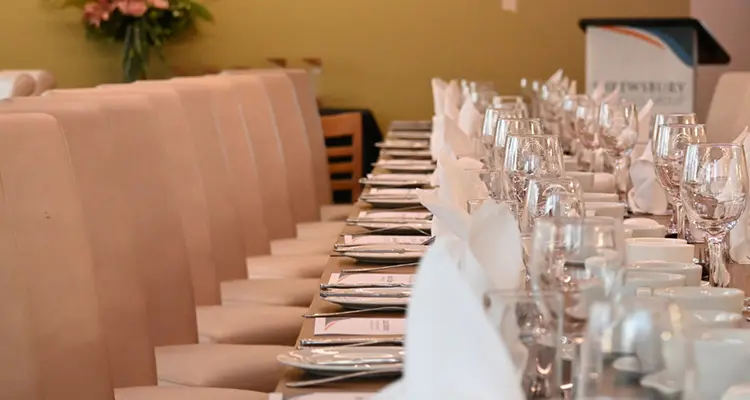 A row of glasses and place settings on a table