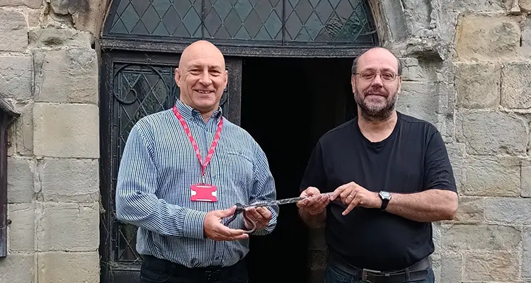 College staff member handing over key to church representative 