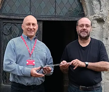 College staff member handing over key to church representative 