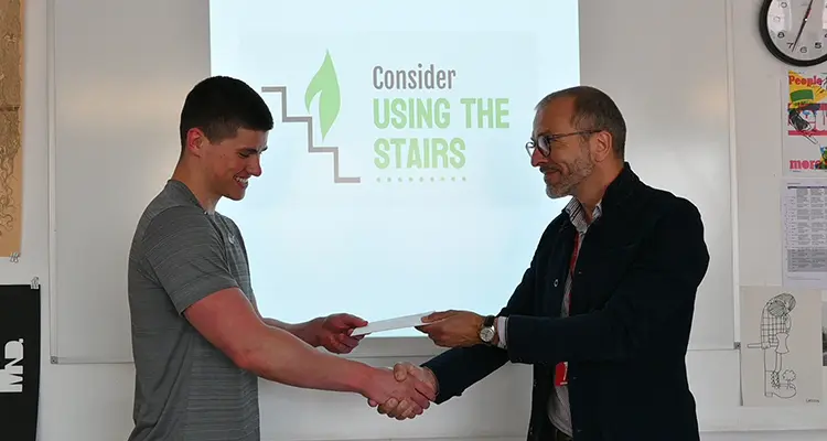 Student shaking hands and receiving certificate from employer