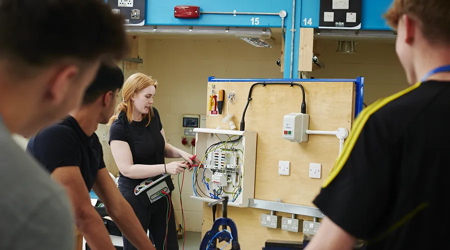 Teacher demonstrating electrical testing to students