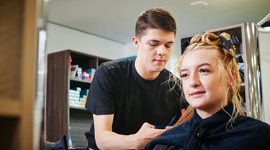 Student cutting customer's hair