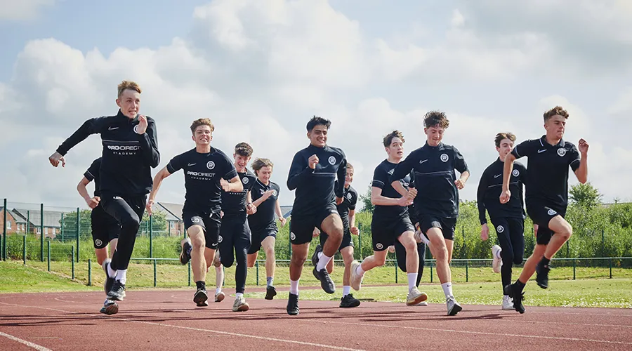 Students on running track in football kit